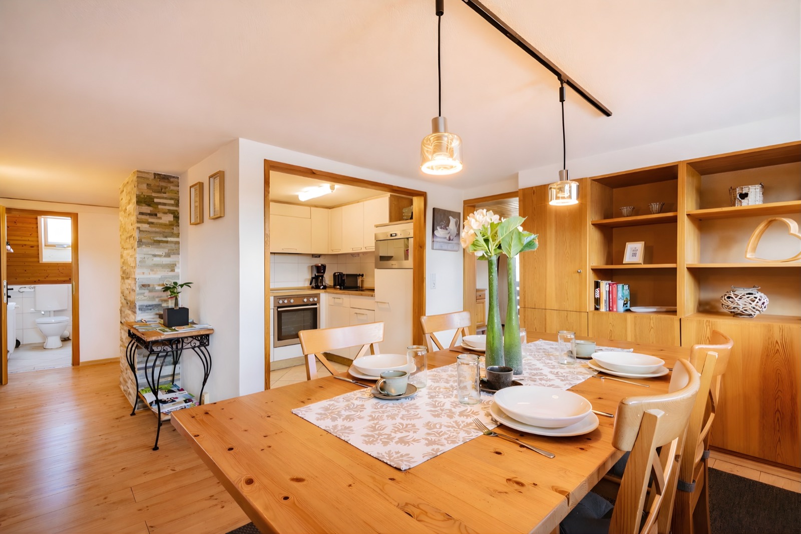 Dining area with a long wooden table and pendant lights