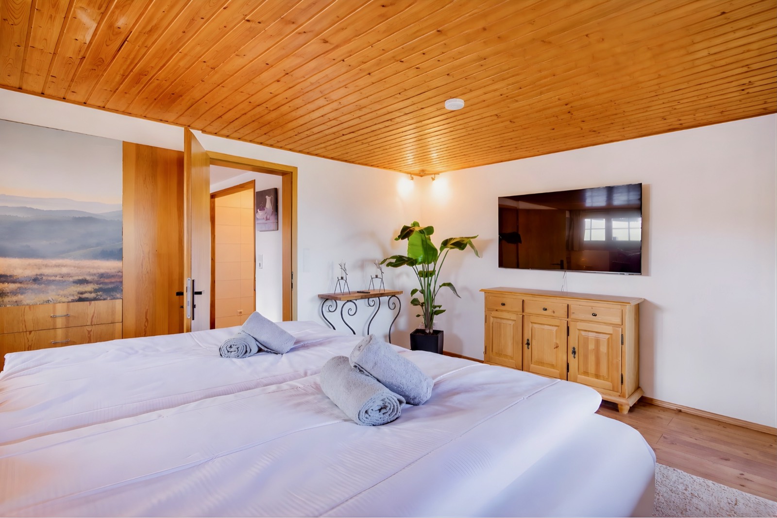 Bedroom with wall mural and spruce ceiling