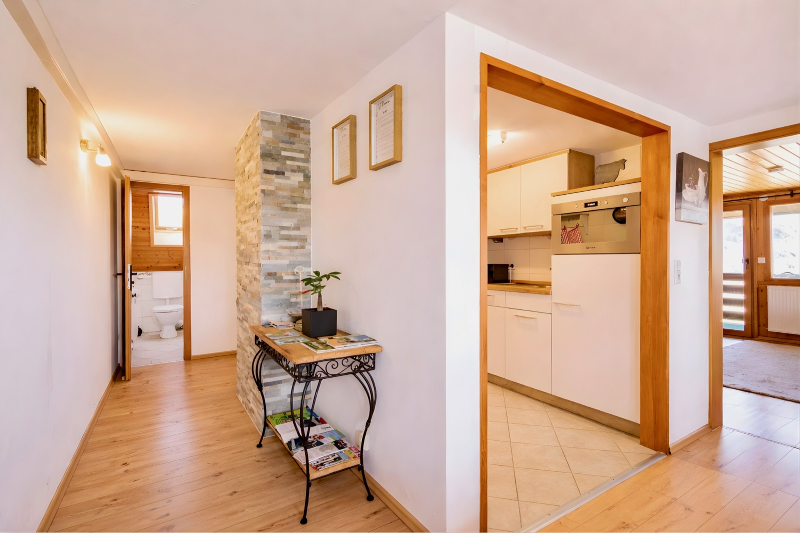 Hallway with natural stone wall, looking into the kitchen