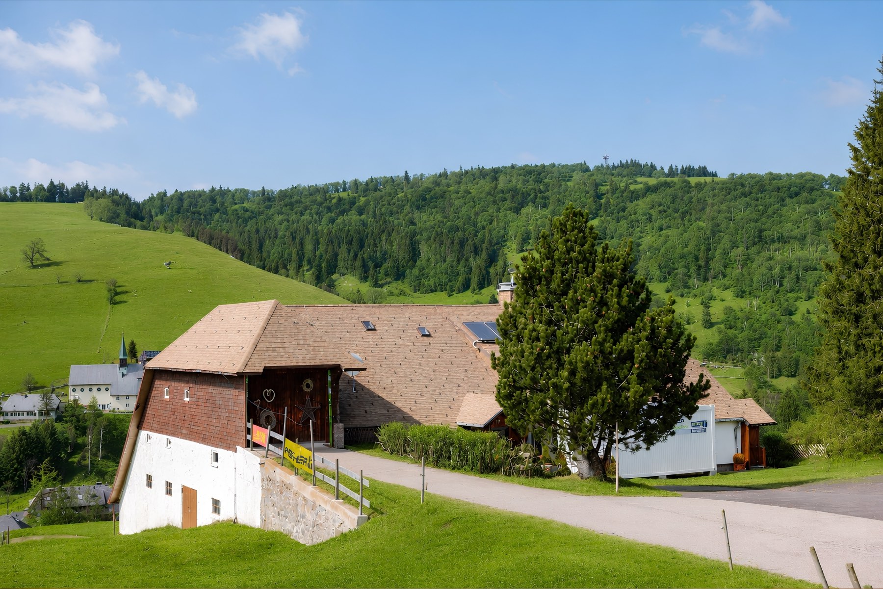 The house on the slope above Hofsgrund, with the village church and forest behind