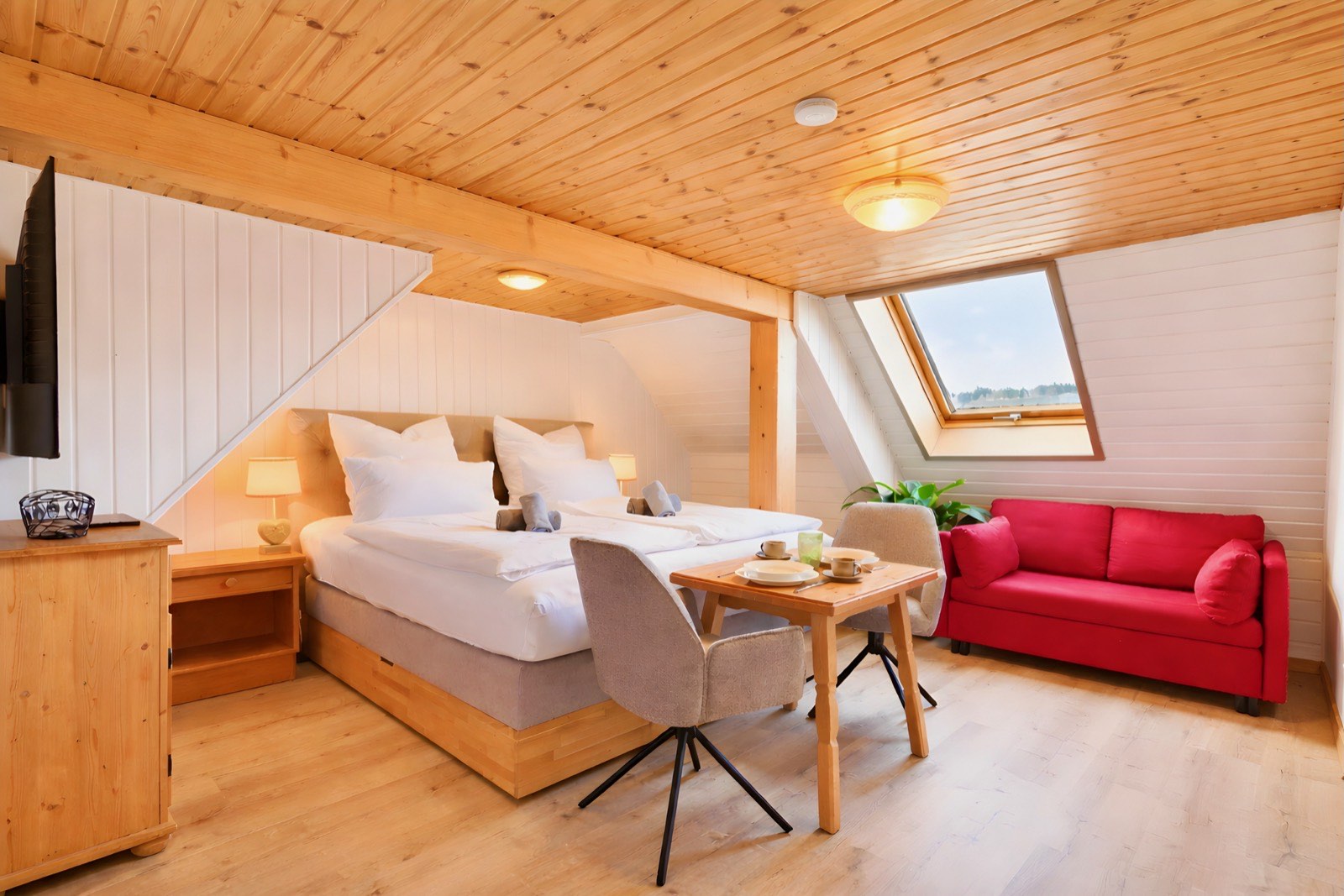 Studio ReesL with red sofa under the sloping roof