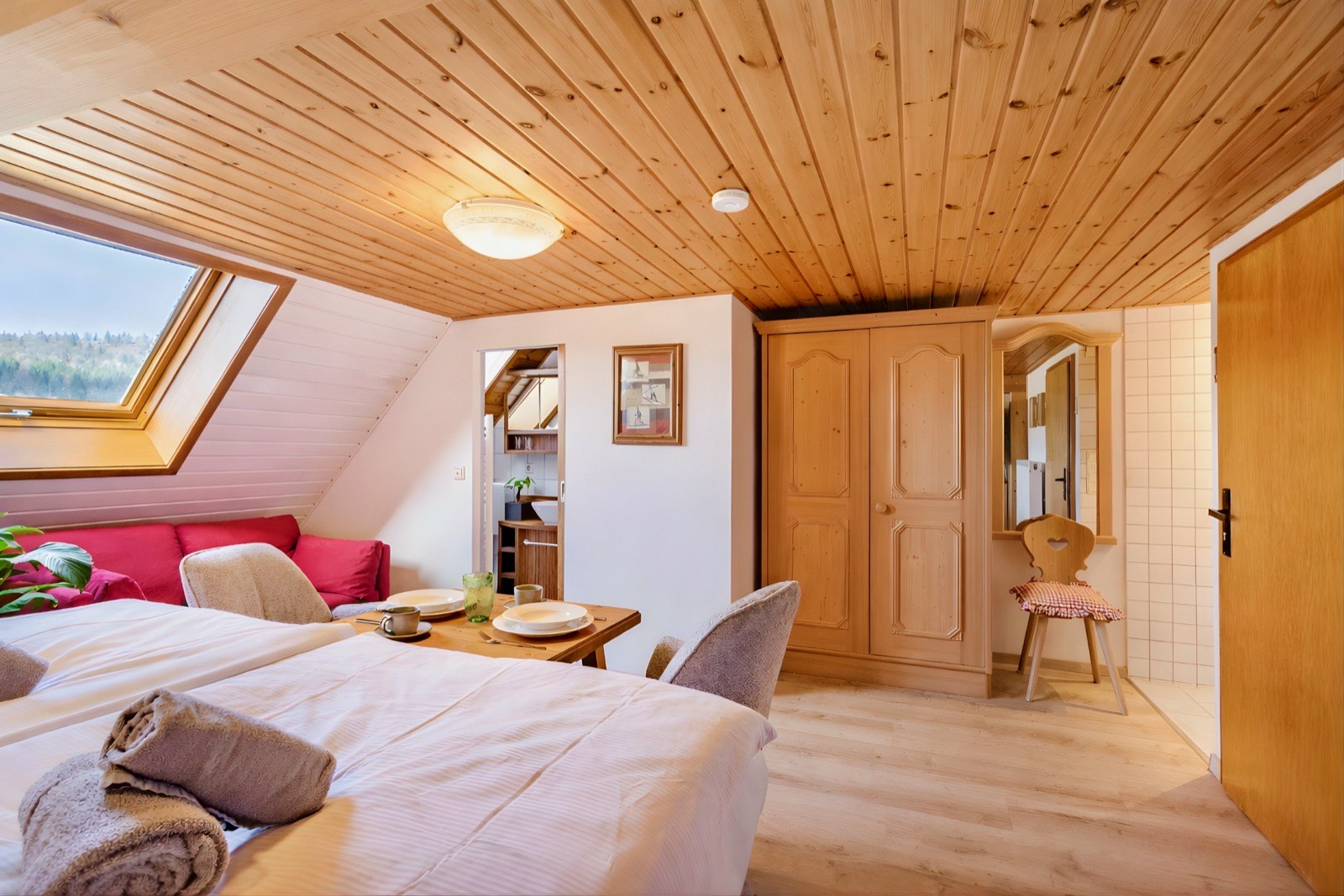 Blick vom Bett zum Dachfenster mit Fichtenholzdecke