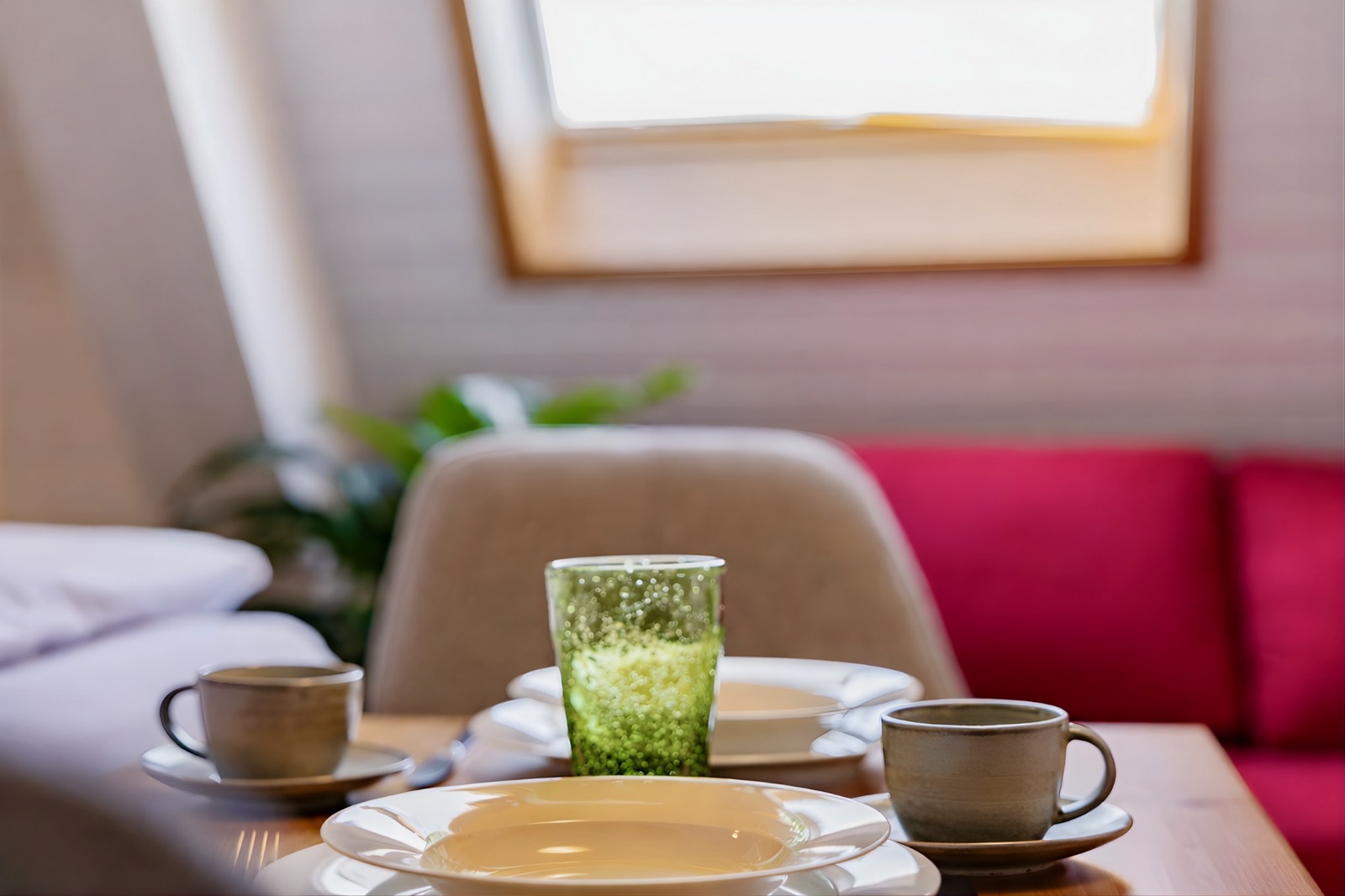 Gedeckter Frühstückstisch mit Tassen und Glas